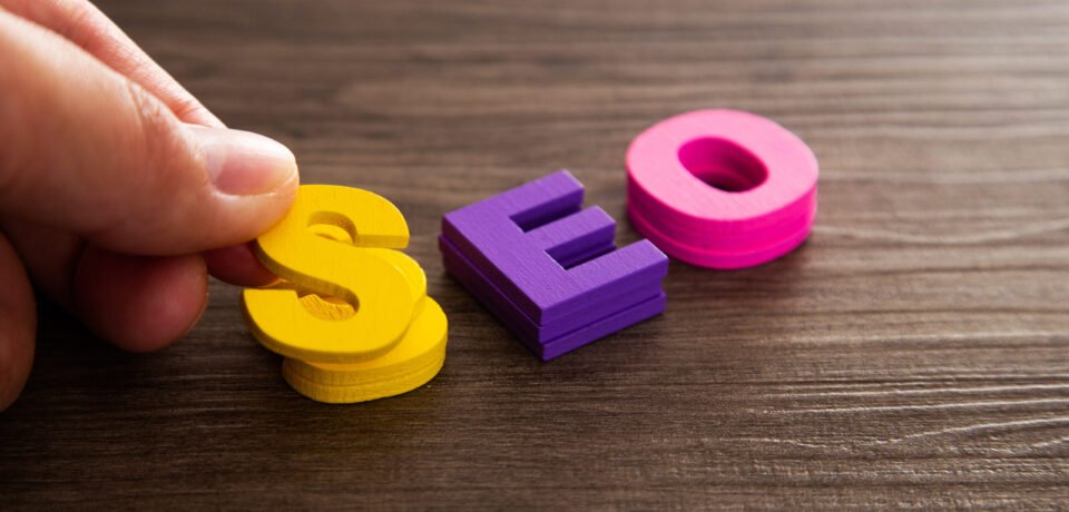 Hand arrange wood letters as SEO abbreviation Search Engine Optimization